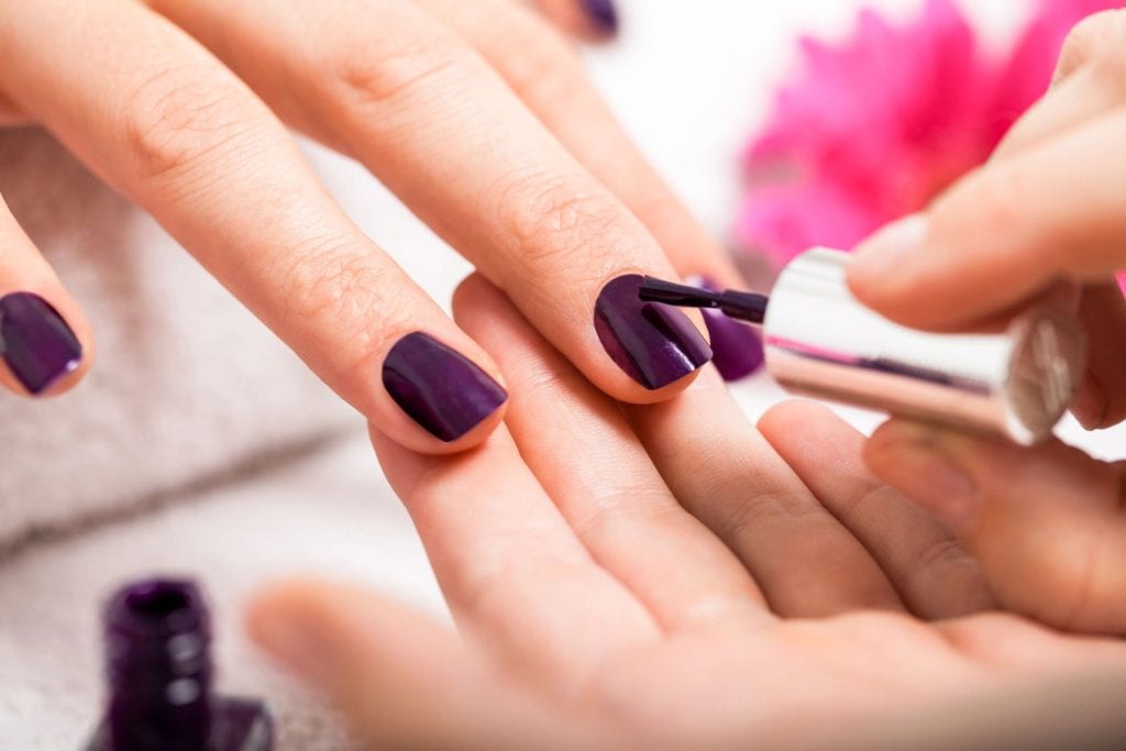 A Lady putting nail Polish to another girls