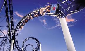 An amusement park roller coaster soaring through the captivating blue sky.