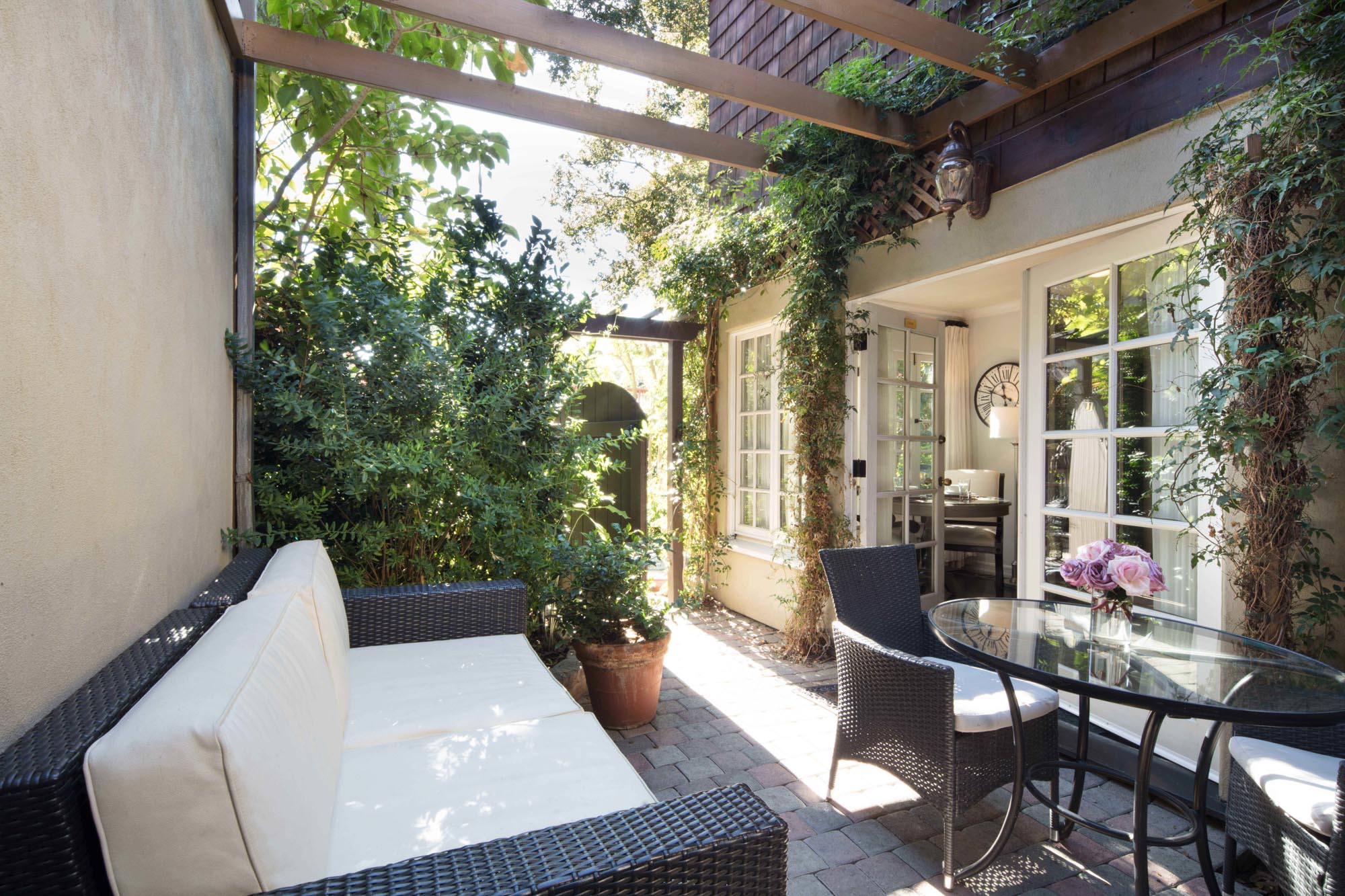 A patio with a wicker couch and table at The Charlie Hotel.