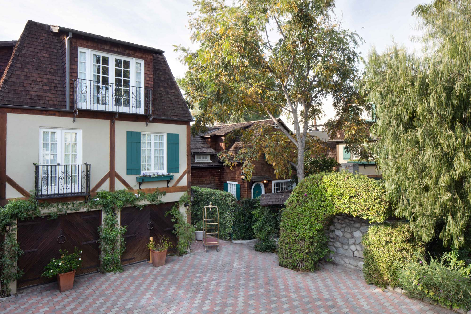 The Charlie Hotel is accessed via a brick driveway, leading to the entrance of the large house.