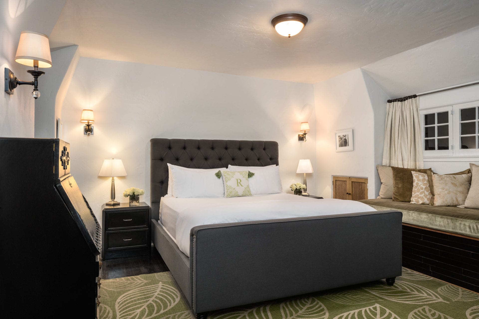 The Charlie Hotel offers a cozy bedroom with a large bed and a green rug.