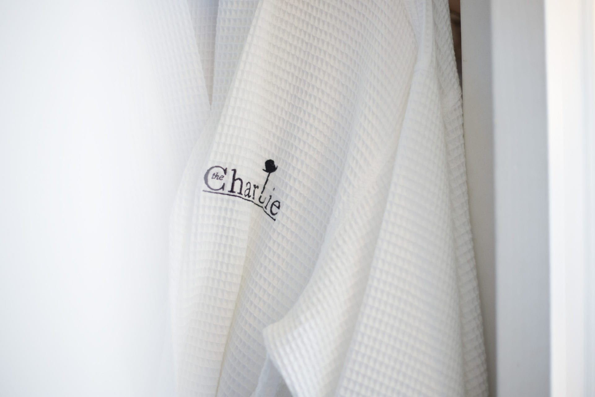 A white robe with the word Charlie Hotel on it.