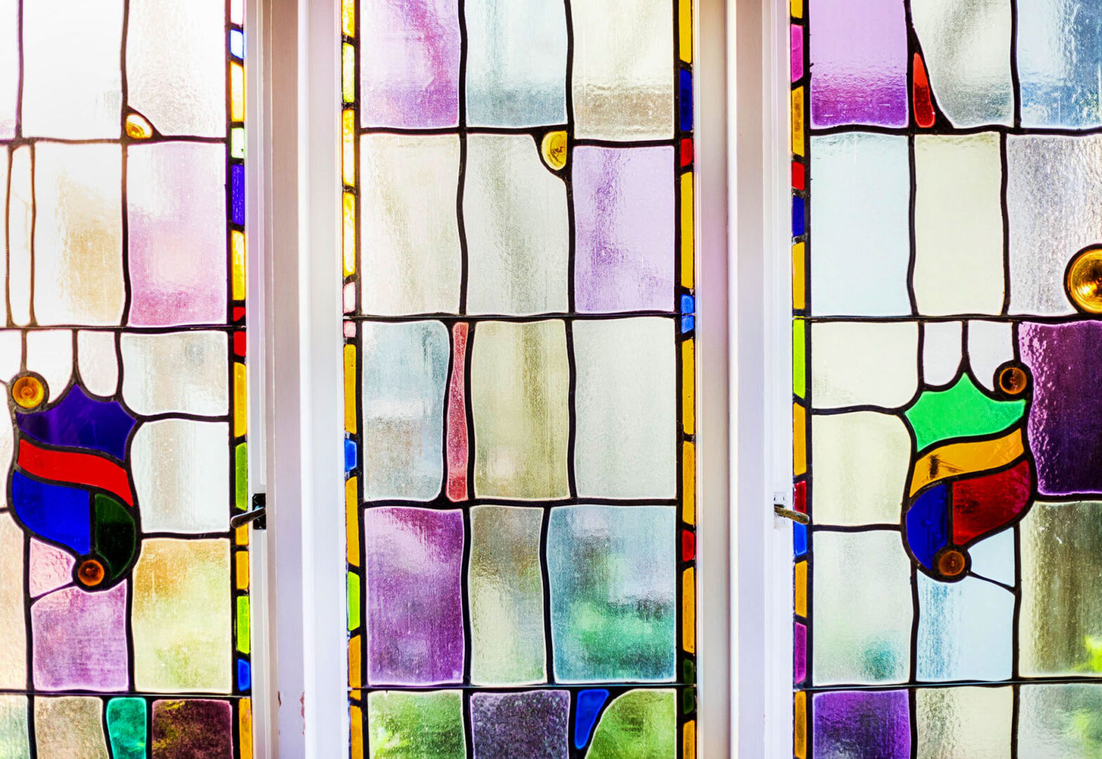 Three stained glass windows in a room.