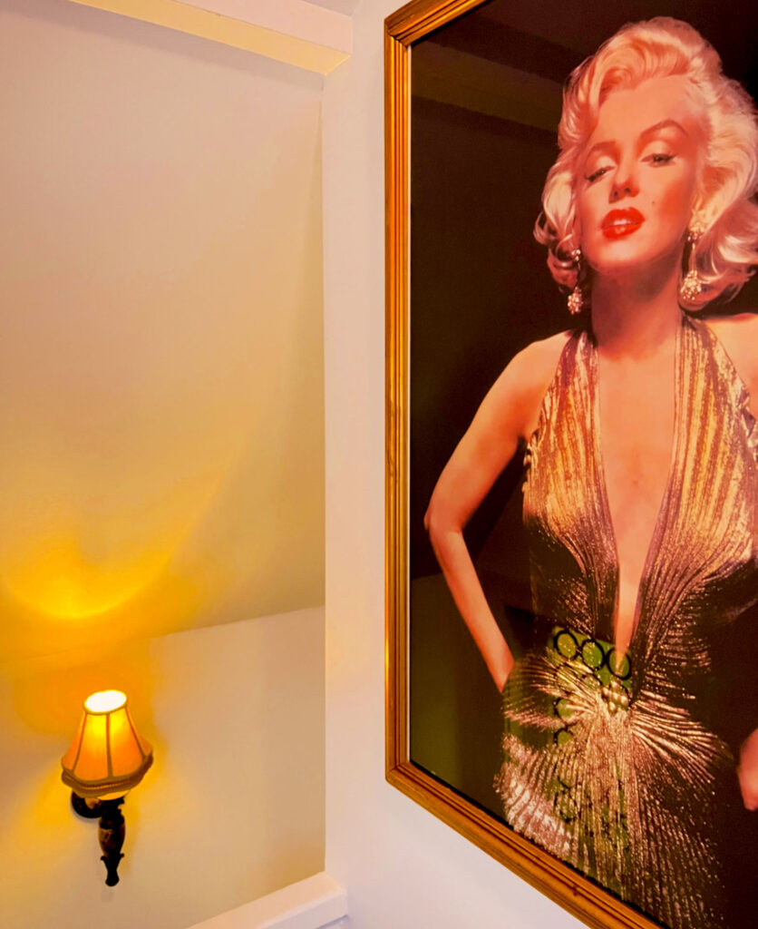 A marilyn monroe framed picture hangs on a wall.