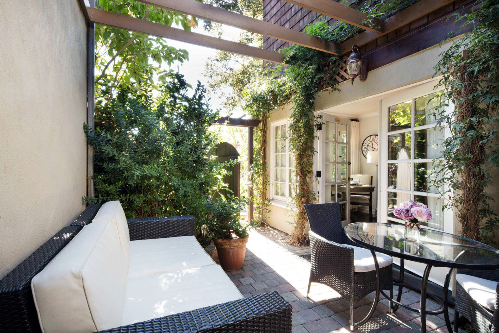 A patio with a wicker couch and table.