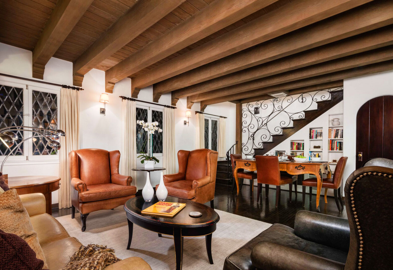 A living room with wooden beams and leather furniture.