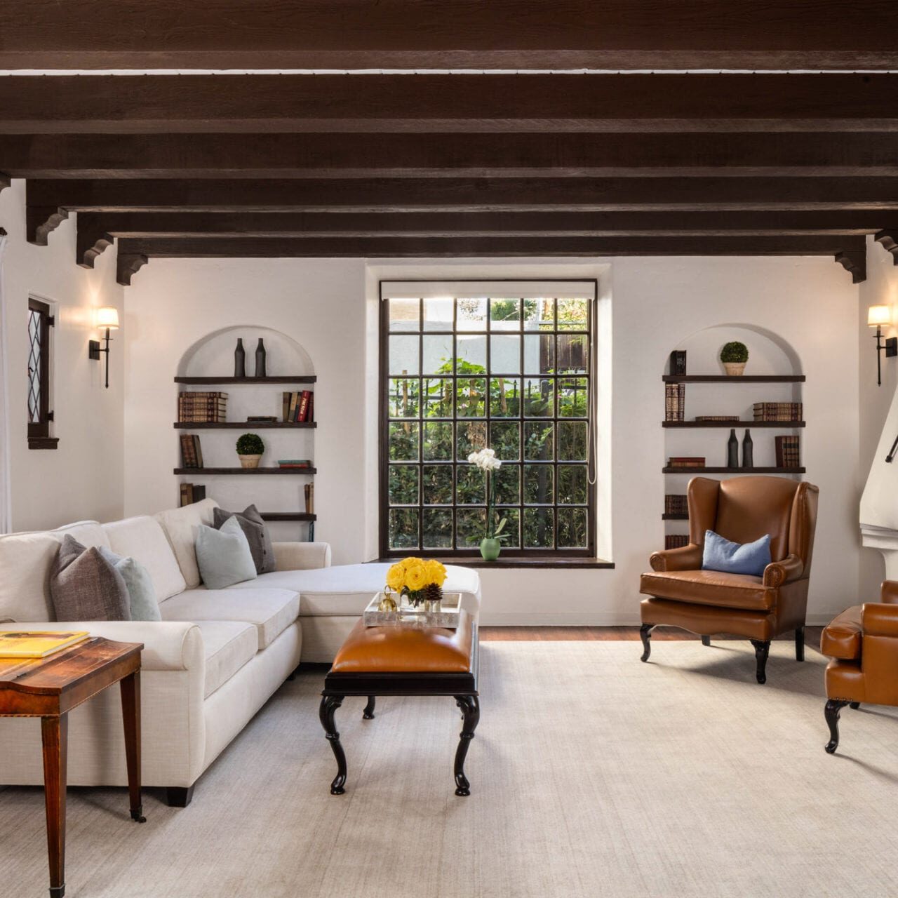 The Charlie Hotel boasts a stunning living room with wood beams and white furniture.